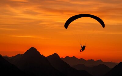 Ride the wind: paraglider silhouette over a painted canyon.